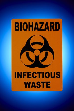 Orange biohazard sign shot in front of glowing blue backgroundの写真素材