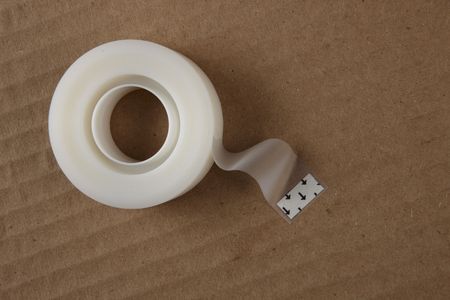 Roll of tape sitting on corrugated boxの写真素材