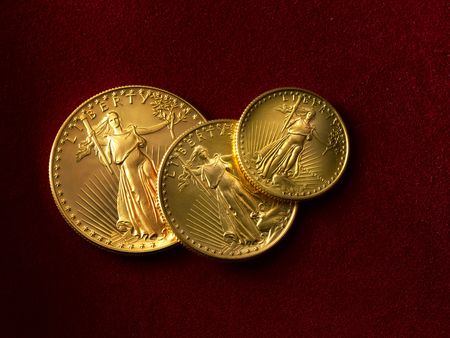 3 gold liberty coins shot on red suadeの写真素材