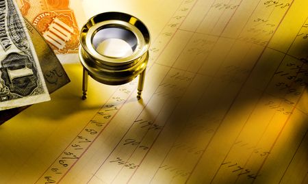 Antique ledger, loupe, stock certificates and money with a warm cast lightの写真素材
