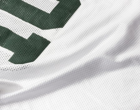 Close up shot of white football jersey with cropped green numberの写真素材