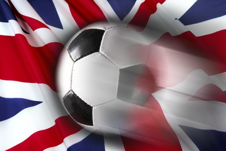 Soccer ball streaks across flag of Britainの写真素材