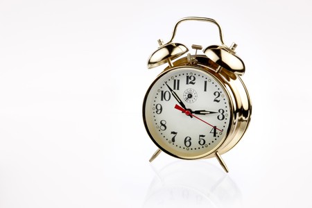 Beautiful classic brass alarm clock with soft reflection shot on white with space for copy