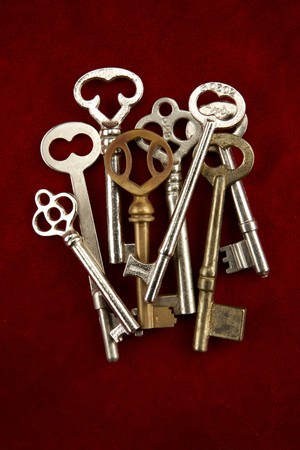 Close up shot of group of overlapping skeleton keys shot on red suedeの写真素材