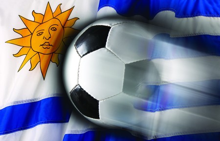 Soccer ball streaks across wavy flag of Uruquayの写真素材