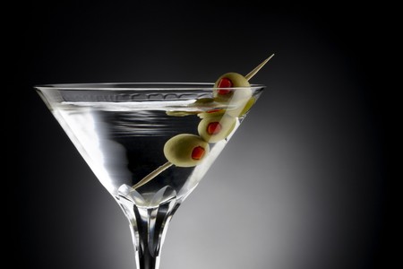 Close up shot of Martini with tooth pick and green olives, shot on black background with space for copyの写真素材