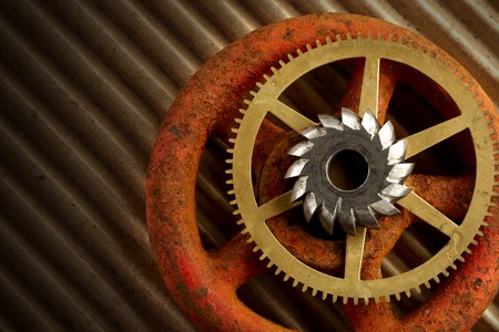 2 gears and a rusty old valve knob shot dramatically on brown corrrugated paperの写真素材
