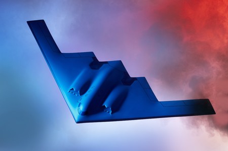Oncoming Stealth B-2 Bomber shot against a blue orange sky with room for copy