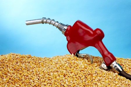 Gas pump sits in a pile of golden corn kernals with space for copyの写真素材