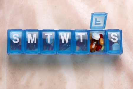 Blue plastic pill organizer shot on marble table with space for copyの写真素材
