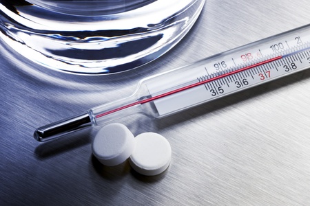 Thermometer, two aspirins and glass of water shot on stainless steel
trayの写真素材