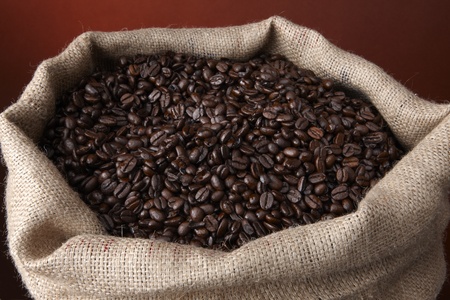Close up shot of burlap sack filled with rich brown coffee beans の写真素材
