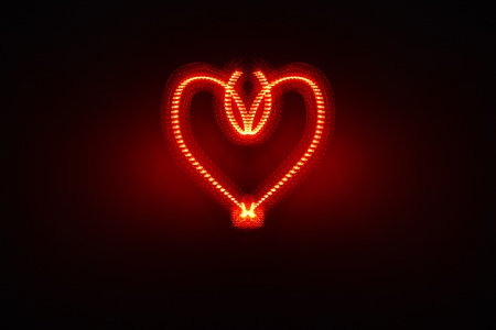 Ornate electric heart produced with red light in studio, includes space for romantic copyの写真素材