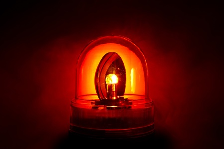 Closeup of a bright red police light shot through a smoky nightの写真素材