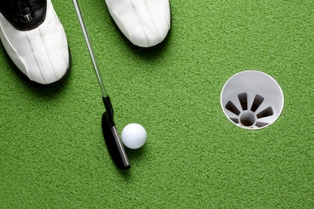 Golfer about to putt ball into cup on greenの写真素材