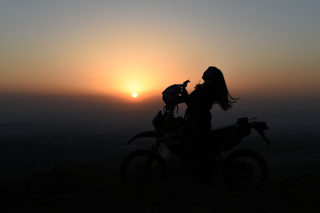 View of a female rider with her bike during sunsetのeditorial素材