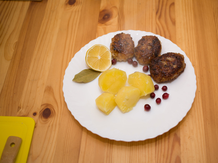 Wiener schnitzel and boiled potatoes with sliced lemonの写真素材