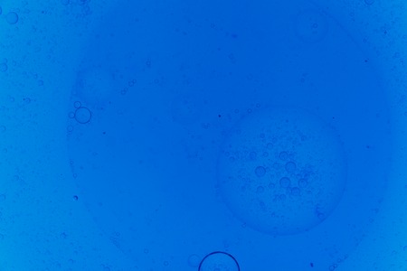 Circles oil on water blue color. Abstract background