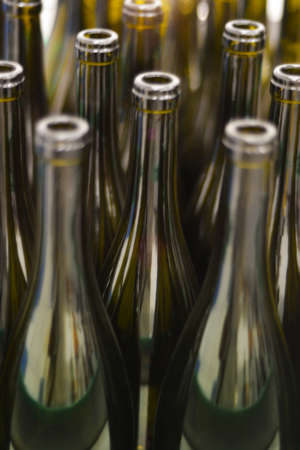 Wine bottles shallow focus blurred foreground defocused background bokeh light sun flares.の写真素材