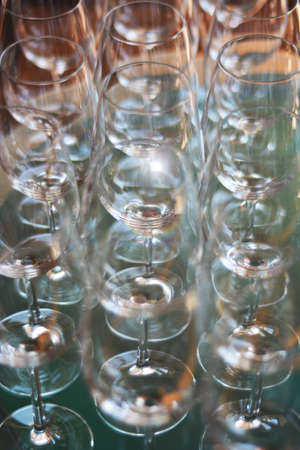 Wine glasses shallow focus blurred foreground defocused background light optical refraction sun flares.の写真素材