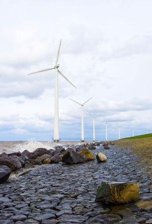 The wind turbines along a dyke in the netherlandsの写真素材