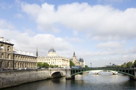 A view over the River Seine, Paris, France, with the sun lighting up the Conciergerie on Ile de la...