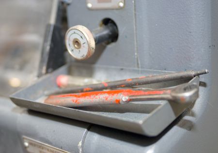 Tools on an offset printing press and a control knob.