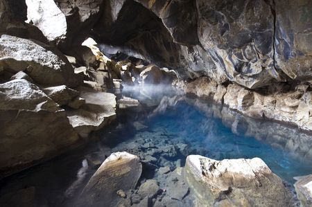 A volcanically formed cave, housing a geothermal hot water spring in the Myvatn area, North Icelandの写真素材