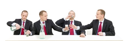 A businessman helping himself to a glass of waterの写真素材