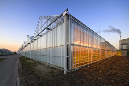 The exterior glass fascade of a huge glasshouse with heating system and generatorの写真素材