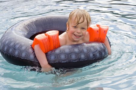 Young boy having fun in an outdoor swimming pool