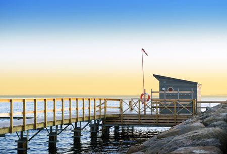Lifeguard station and pier on a tranquil evening on the south coast of Sweden, looking out towards Danemarkの写真素材