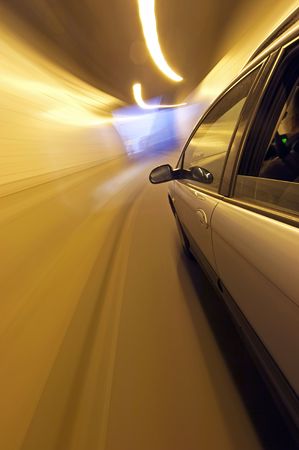 A car speeding, nearing the exit of a tunnel, seen from outside the vehicleの写真素材