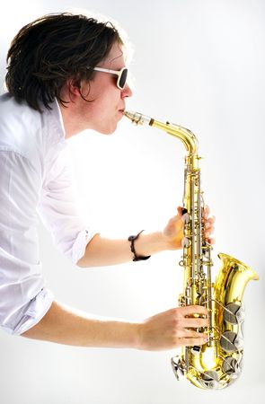 A high key image of a saxophone player held vertical with a strong backlit light sourceの写真素材