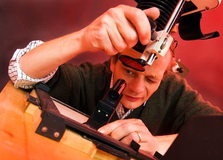 Photographger in a darkroom finetuning the focus of the enlarger, peering through a focus scopeの写真素材