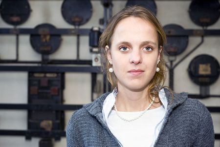 A portrait of a confident, slightly arrogant, looking woman, in front of an - out of focus - industrial grunge backgroundの写真素材