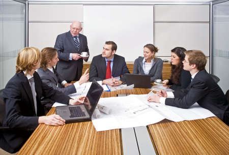 A group of six junior associates during a management team meeting with a senior manager