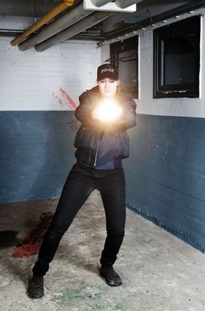 Policewoman aiming a flashlight in pursuit of a suspect