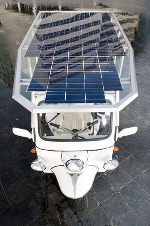 Tuc tuc with solar panels on its roof in a business districtの写真素材
