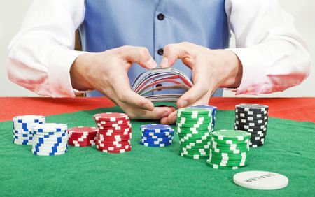A dealer shuffling cards at a poker table