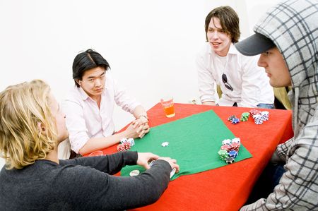 Four people sitting around a square poker table for a private casual gameの写真素材