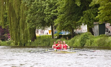 A coxed four on a canal at full speed