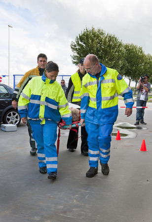 Emergency medical services team carrying away an injured woman from a car crash on a stretcherの写真素材