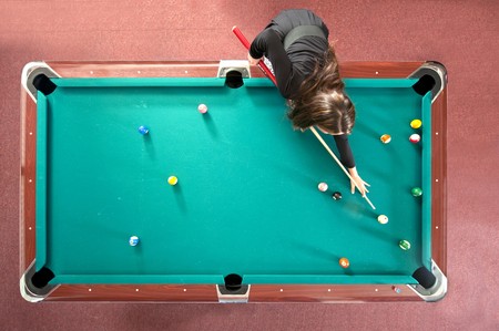 Pool table with a girl playing, seen from aboveの写真素材