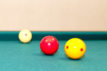 Three billiard balls, used for caroms or carambole on a table, with selective focus on the red ballの写真素材