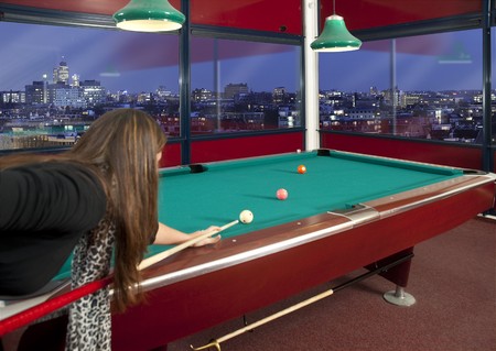 Young woman playing pool in a metroplitan environment