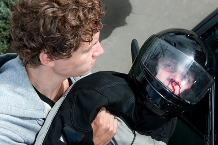 Gruesome image of a bystander lifting the lifeless body of a motorist after a car crashの写真素材