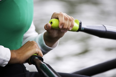 Close up of hands and oar handles of a woman's single sculls rowerの写真素材