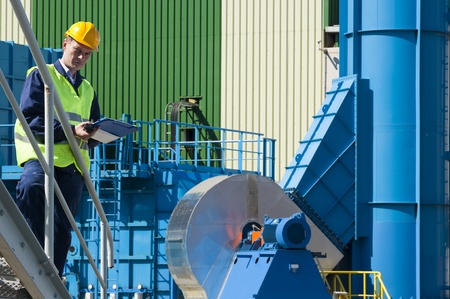 Safety inspector taking notes outside a factory