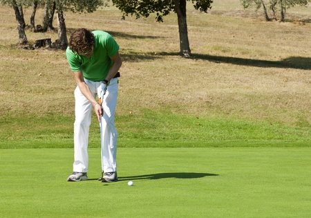 Golfer concentrating for a put on the green of a colf courseの写真素材